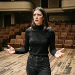 Jeune comédienne en répétition sur scène dans une école de théâtre parisienne, évoquant la formation au Cours Florent